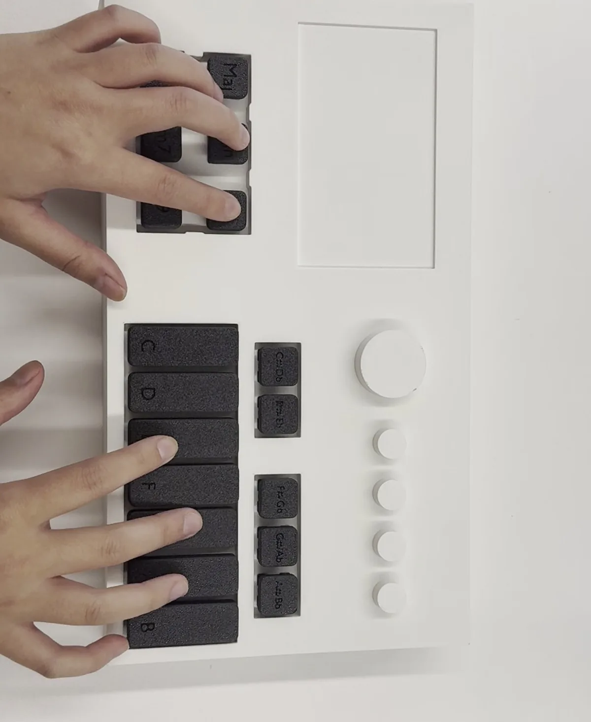 The creator's working prototype of Project Play: a 3D-printed body with keycaps, being played on a desk